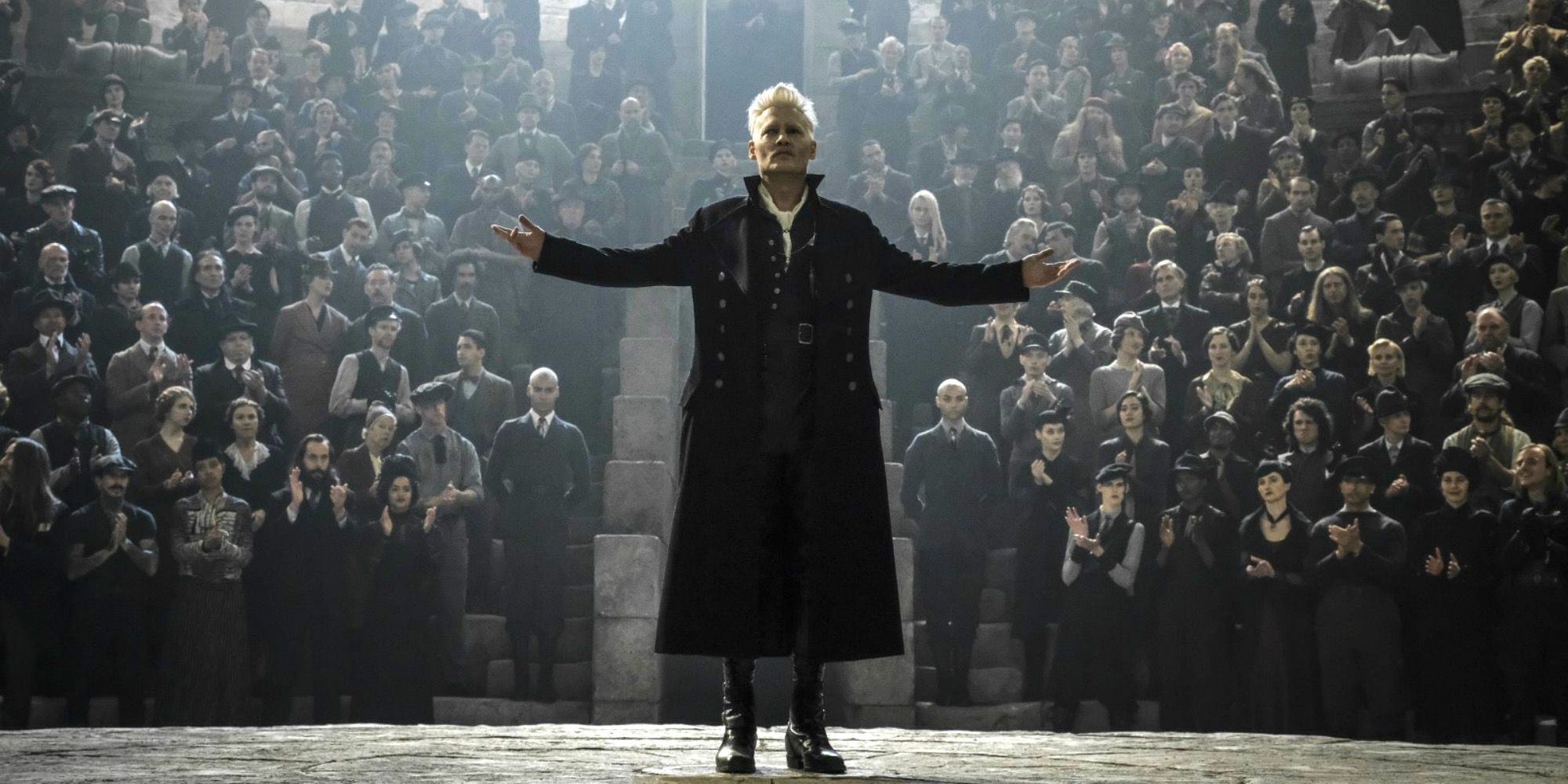 Johnny Depp como Grindelwald com os braços abertos na frente de uma multidão