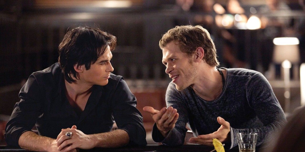 Damon e Klaus sentados e conversando em The Vampire Diaries