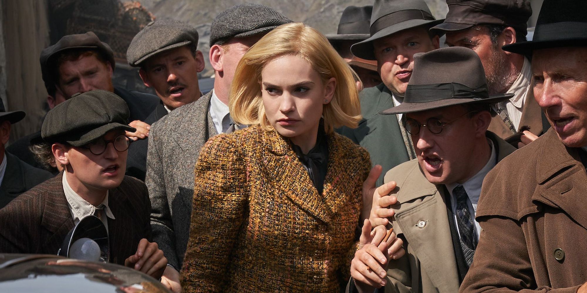 Lily James pushes through crowd in Rebecca