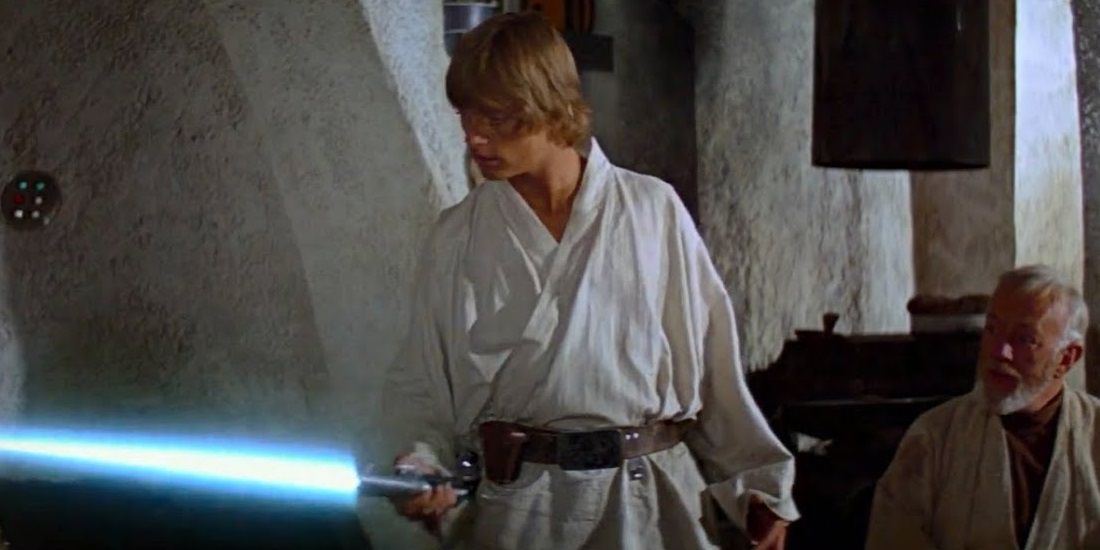 Luke Skywalker holds his father's lightsaber