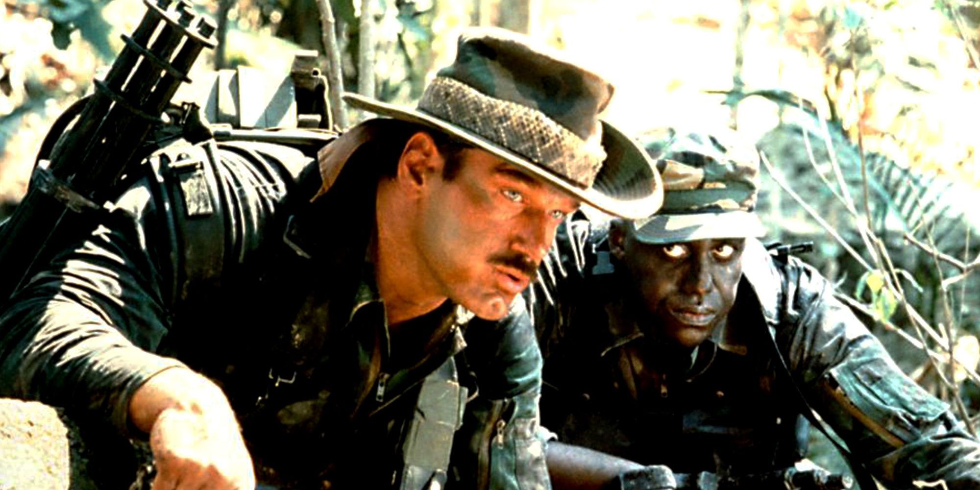 Bill Duke and Jesse Ventura in crouching in the jungle in Predator