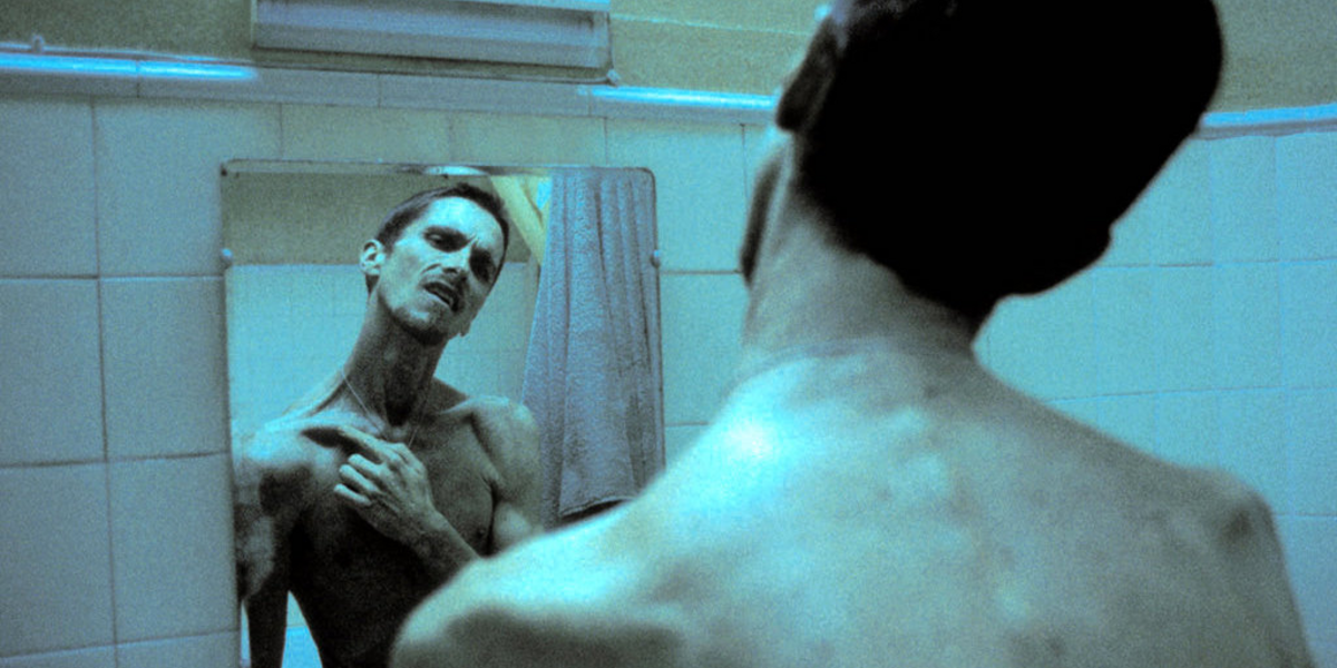 Christian Bale staring at himself in the mirror in The Machinist