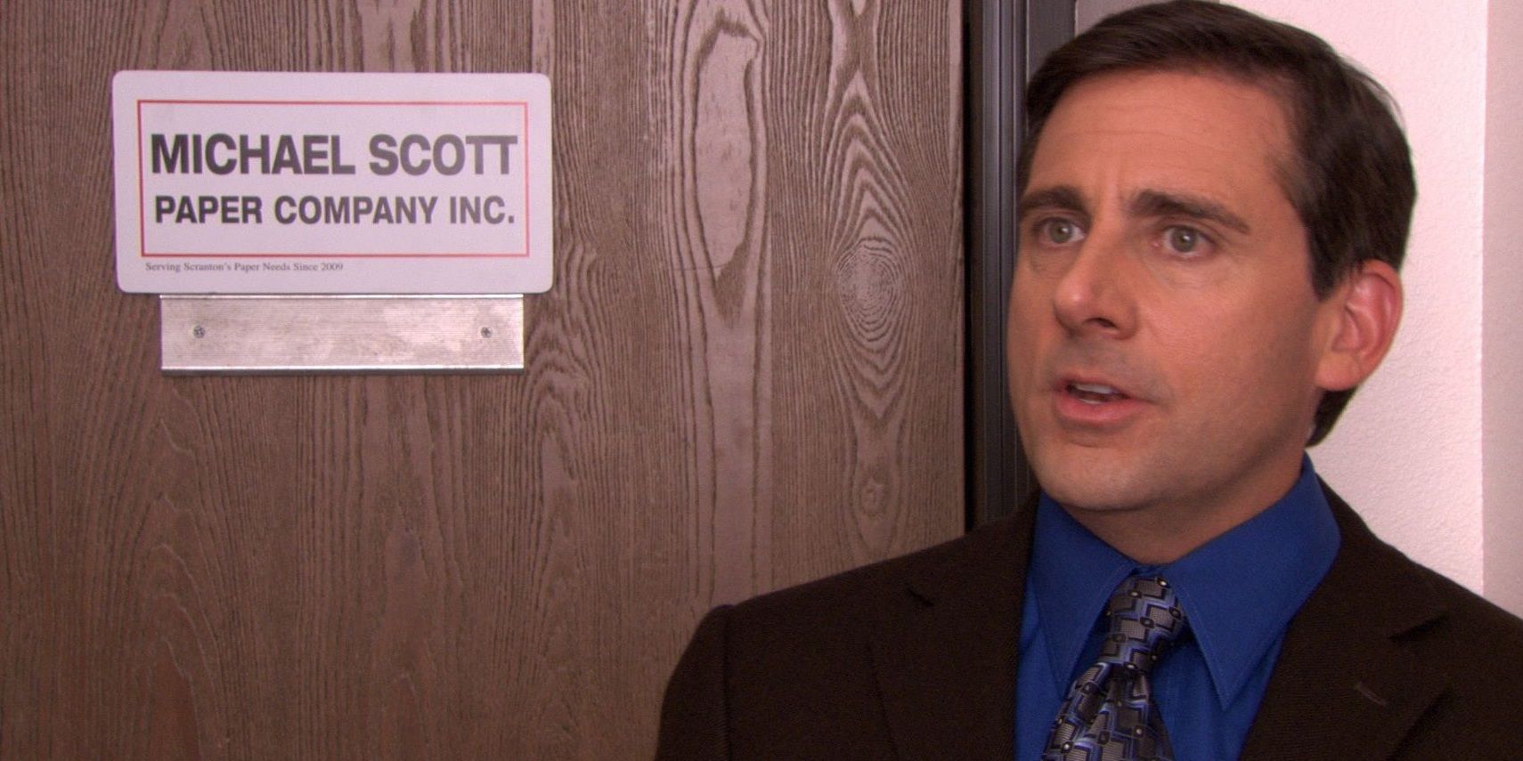 Michael standing in front of the door for Michael Scott Paper Company in The Office