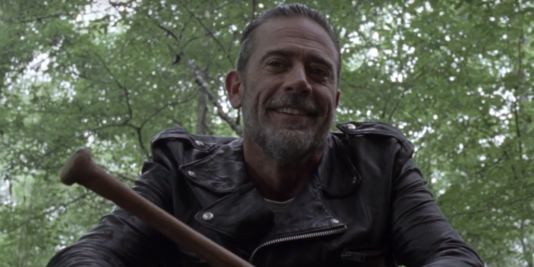 negan smiling as he holds a bat