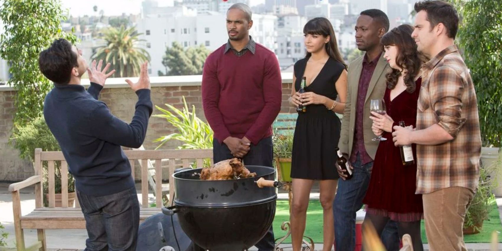 Schmidt yells on the roof while his friends watch and something is grilling in New Girl S4E09 Thanksgiving IV