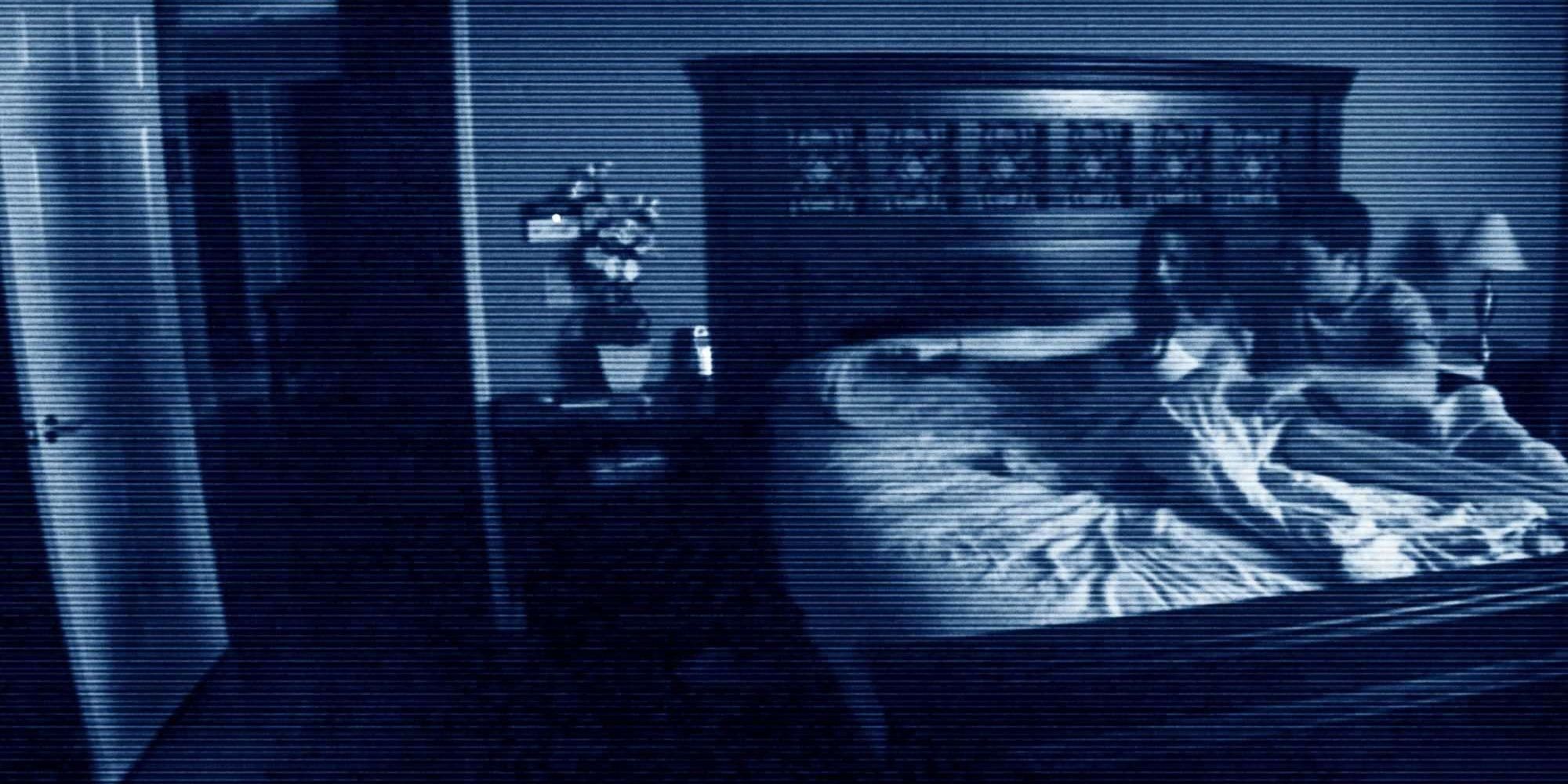 Katie points out at her bedroom door while at bed with Micah in Paranormal Activity