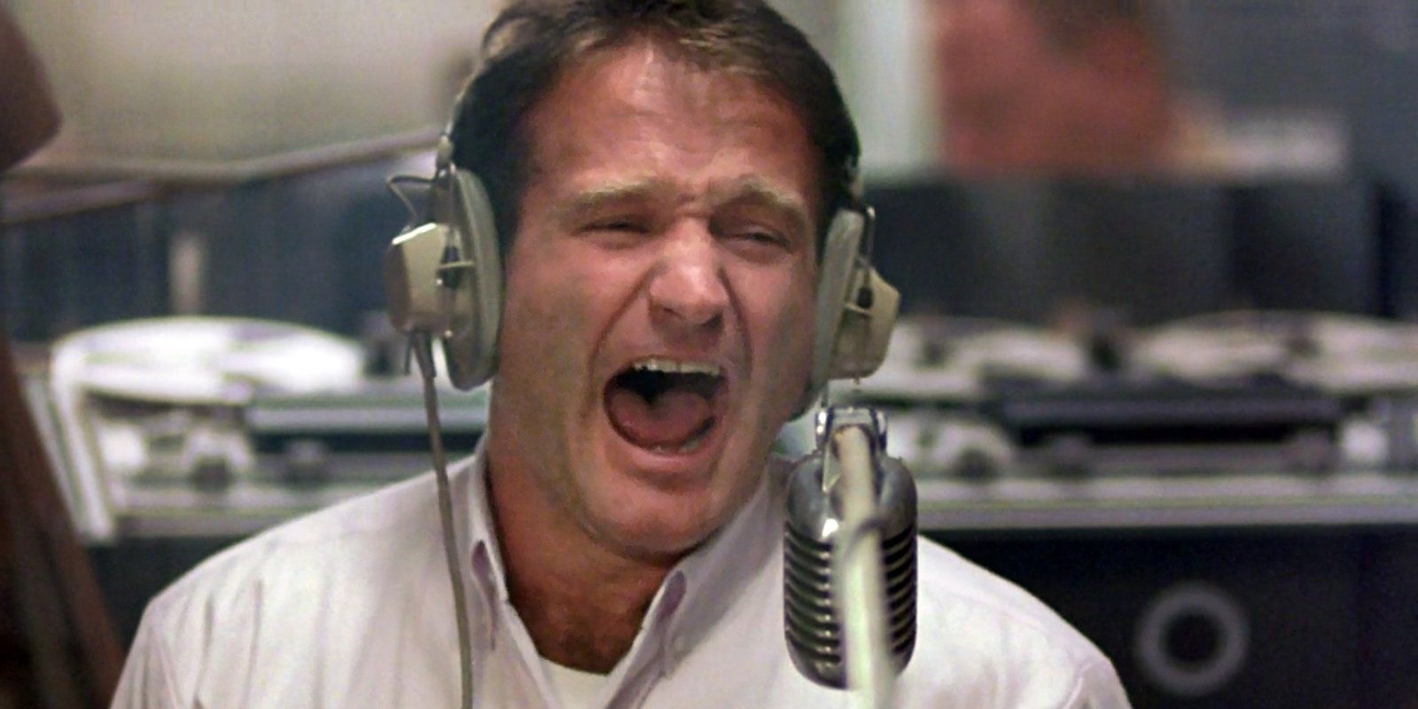 Adrian Cronauer yelling into a microphone in Good Morning Vietnam