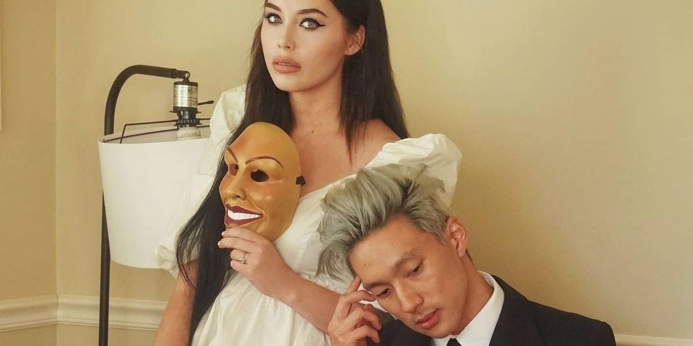 Deavan Clegg holding up a Halloween mask wearing white dress posing with Topher Park wearing a black suit TLC: 90 Day Fiancé