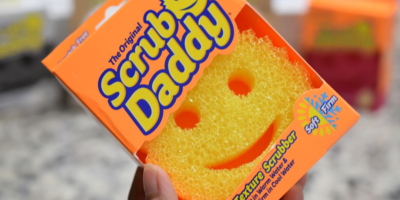 A hand holding up the Scrub Daddy product