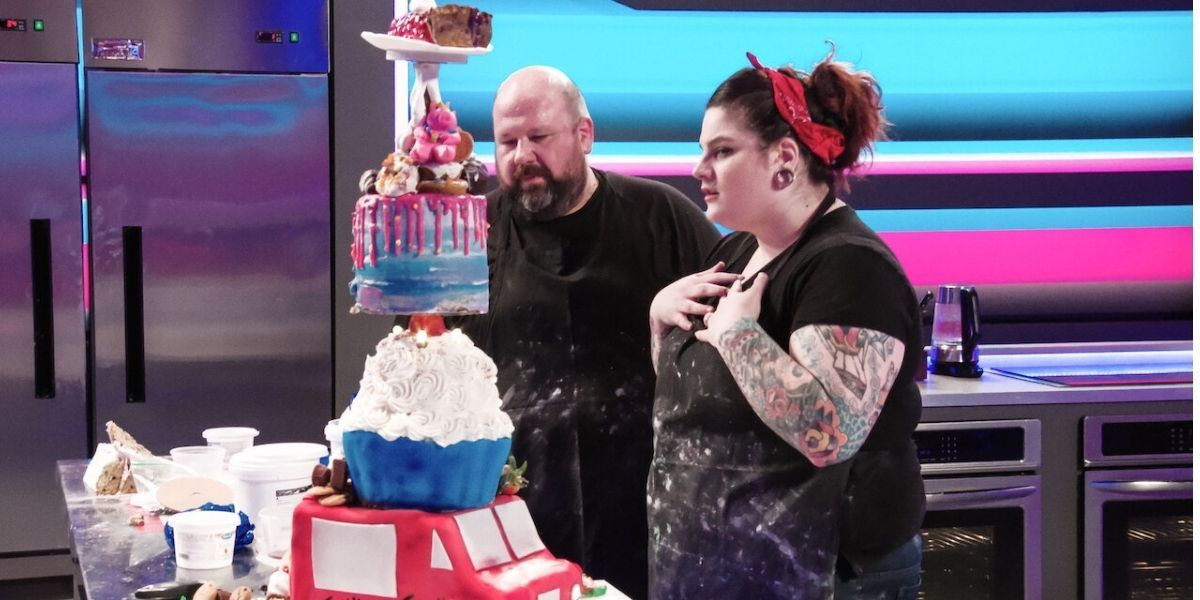2 contestants on Sugar Rush looking at their stacked tiered cake