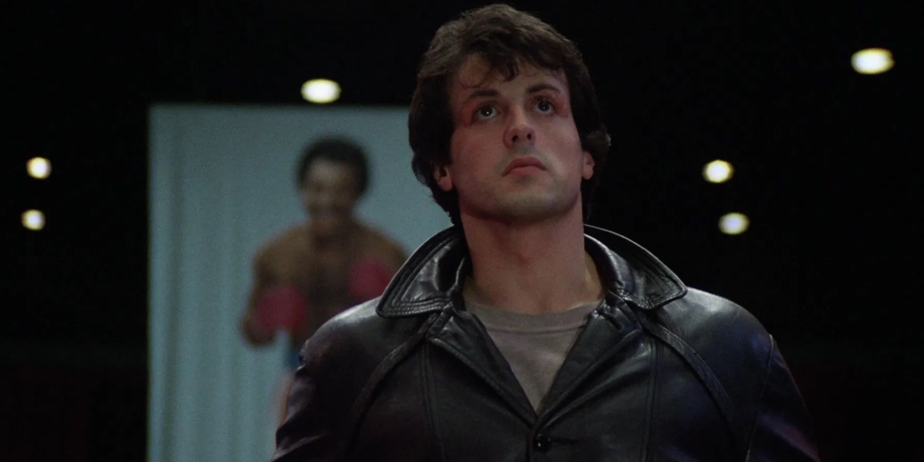 Sylvester Stallone como Rocky Balboa observando contemplando a arena de boxe em Rocky
