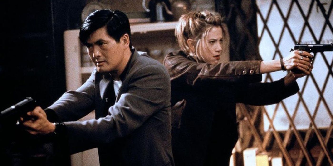 Chow Yun Fat and Mia Sorvino pointing guns and standing back to back in The Replacement Killers