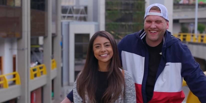 Tim Clarkson and Melyza Zeta from 90 Day Fiancé laughing outside airport