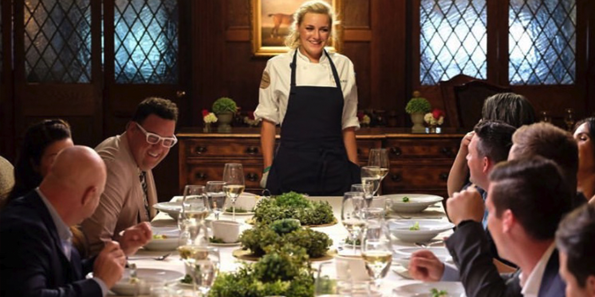 Top chef still, contestant stands before table