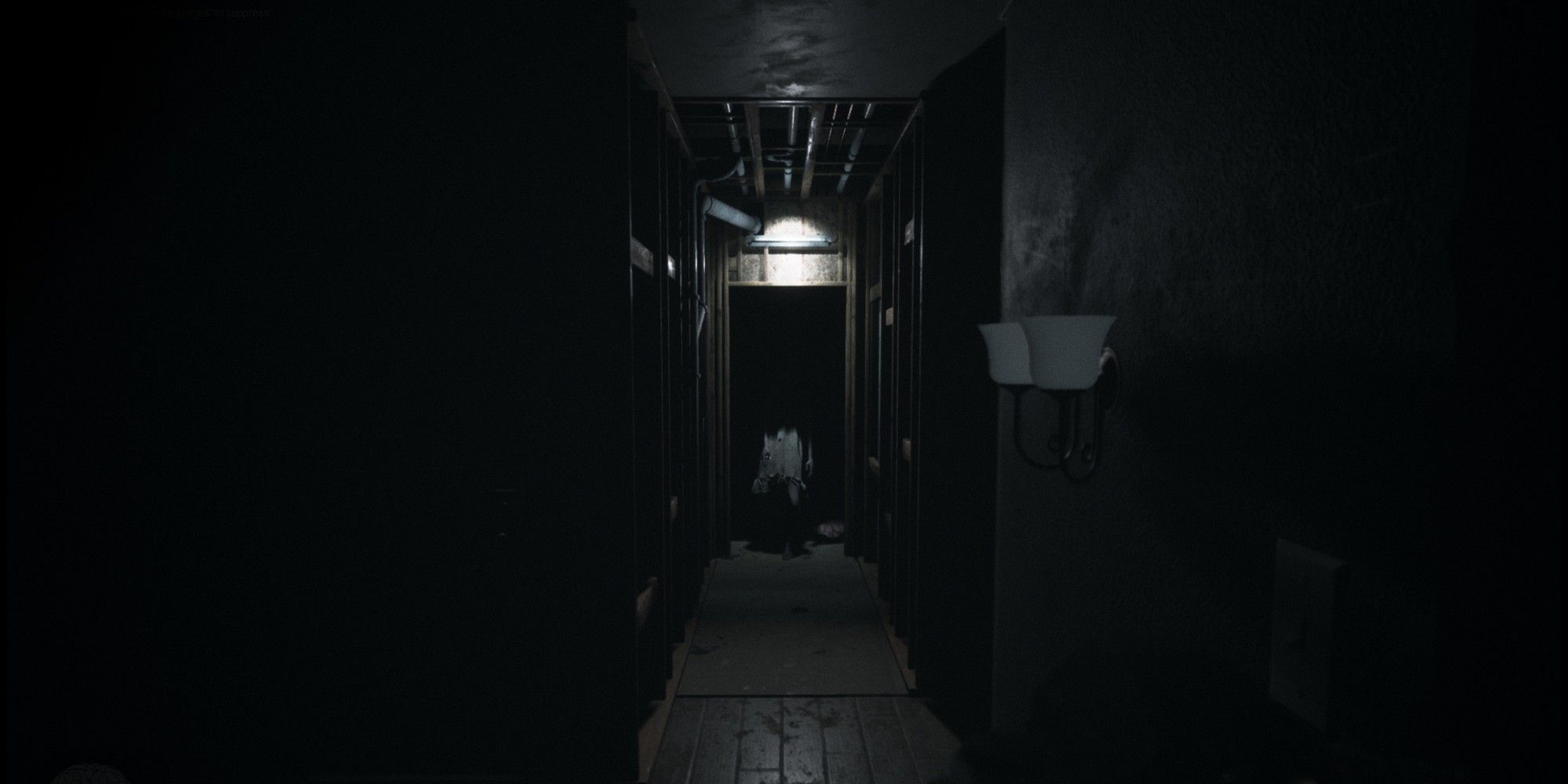 A dark hallway in Visage with a figure at the far end