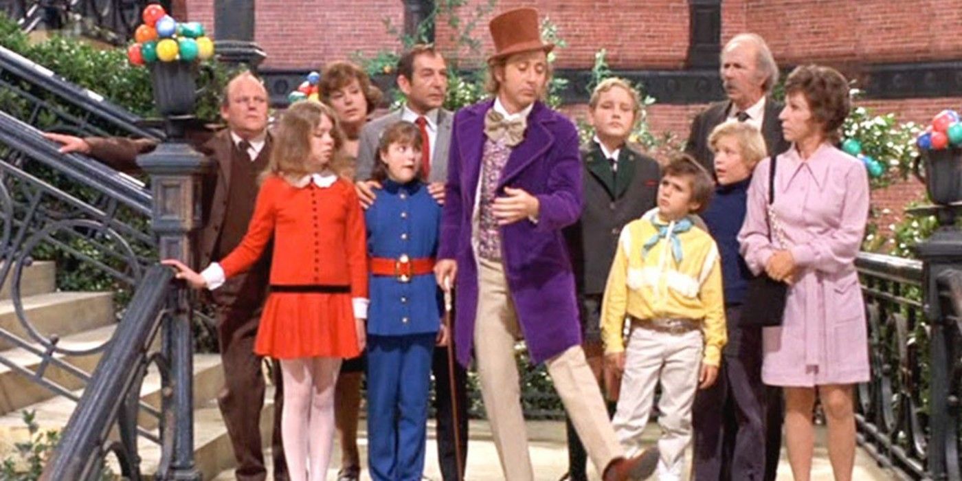 Willy Wonka, the children, and their parents stand on a staircase overlooking the chocolate river in Willy Wonka and the chocolate Factory