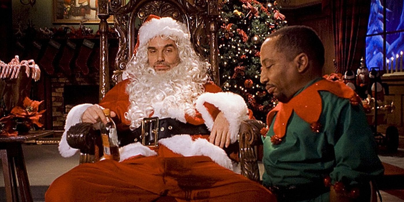 Billy Bob Thornton slumped in his chair in a Santa outfit, a man dressed as en elf beside him in Bad Santa.