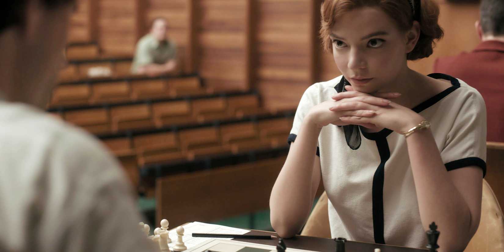 Beth Harmon with her hands folded under her chin during a chessmatch in The Queen's Gambit