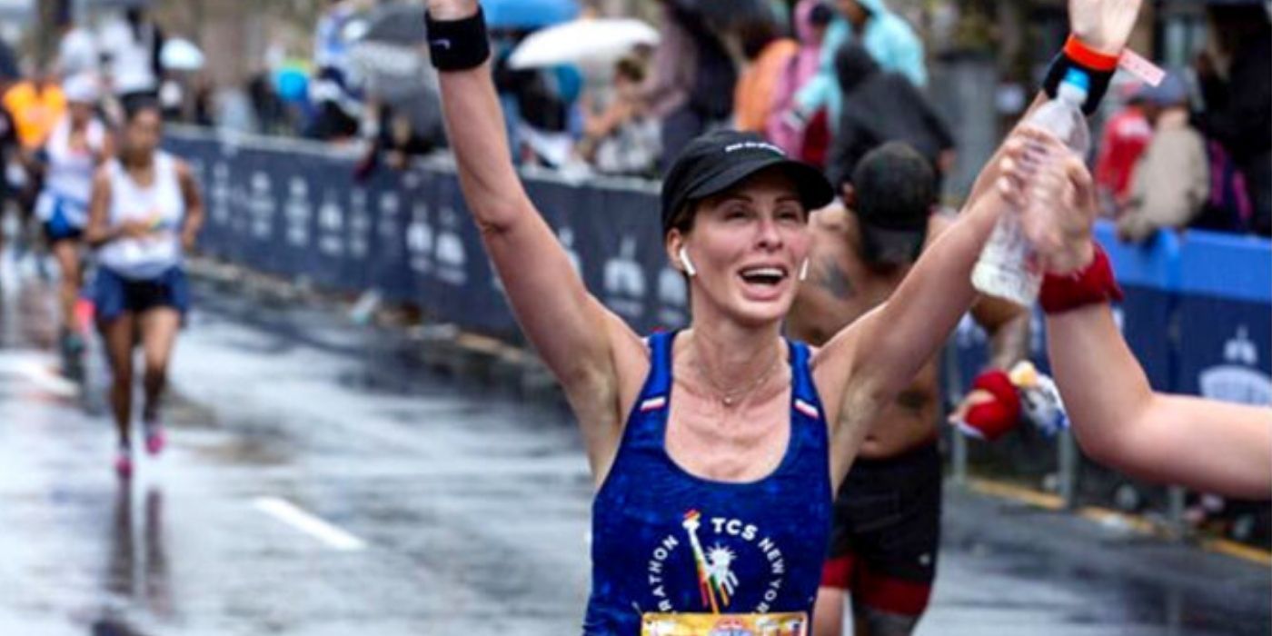 Carole cheering as she finishes a marathon on RHONY