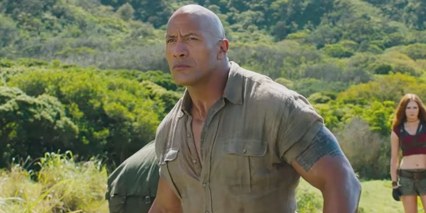 Dwayne Johnson in Jumanji looking off into the distance outside.