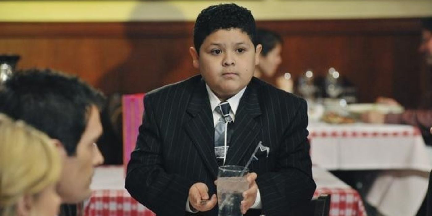 Manny standing at dinner on his birthday on Modern Family
