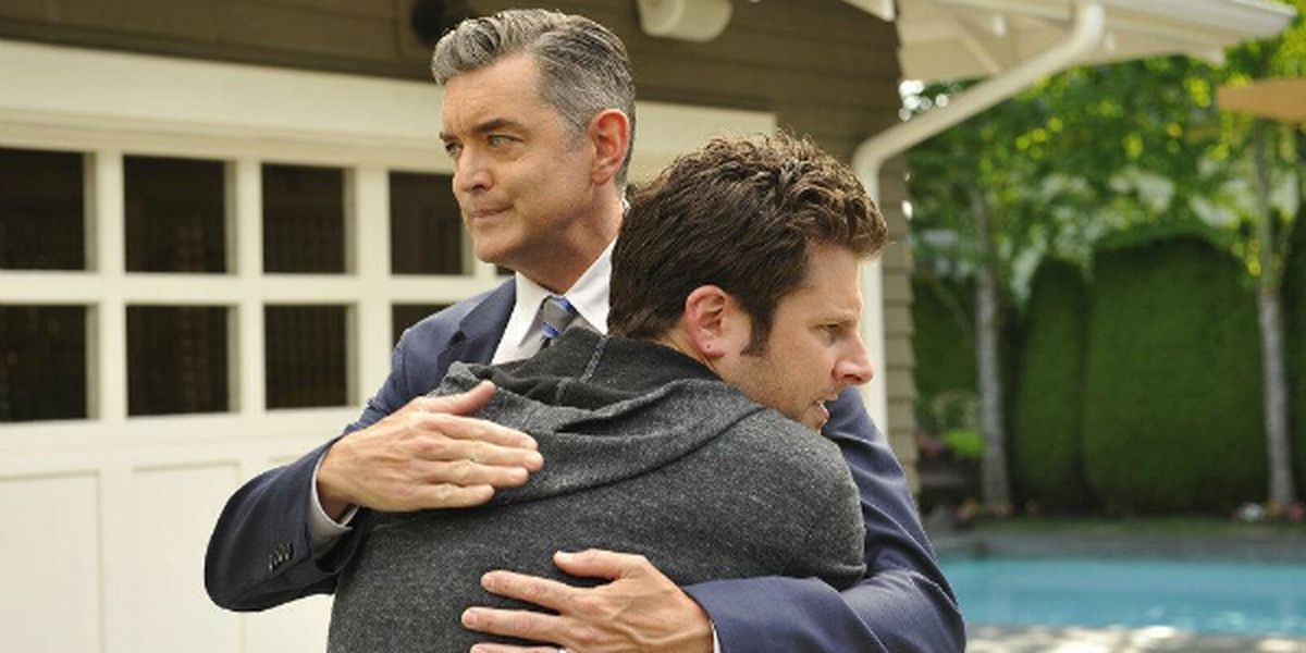 Carlton Lassiter looks amused as he hugs Shawn Spencer in Psych