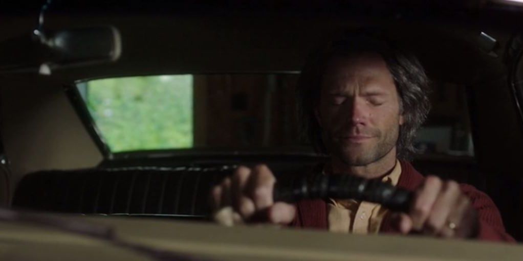 An oder Sam Winchester sits in the Impala in Supernatural