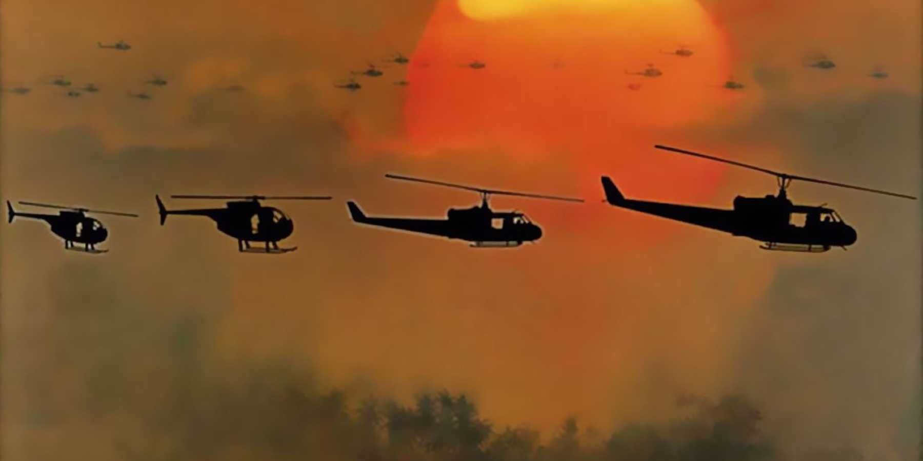 Cuatro helicópteros vuelan en la distancia con el sol abrasador de fondo en Apocalypse Now.