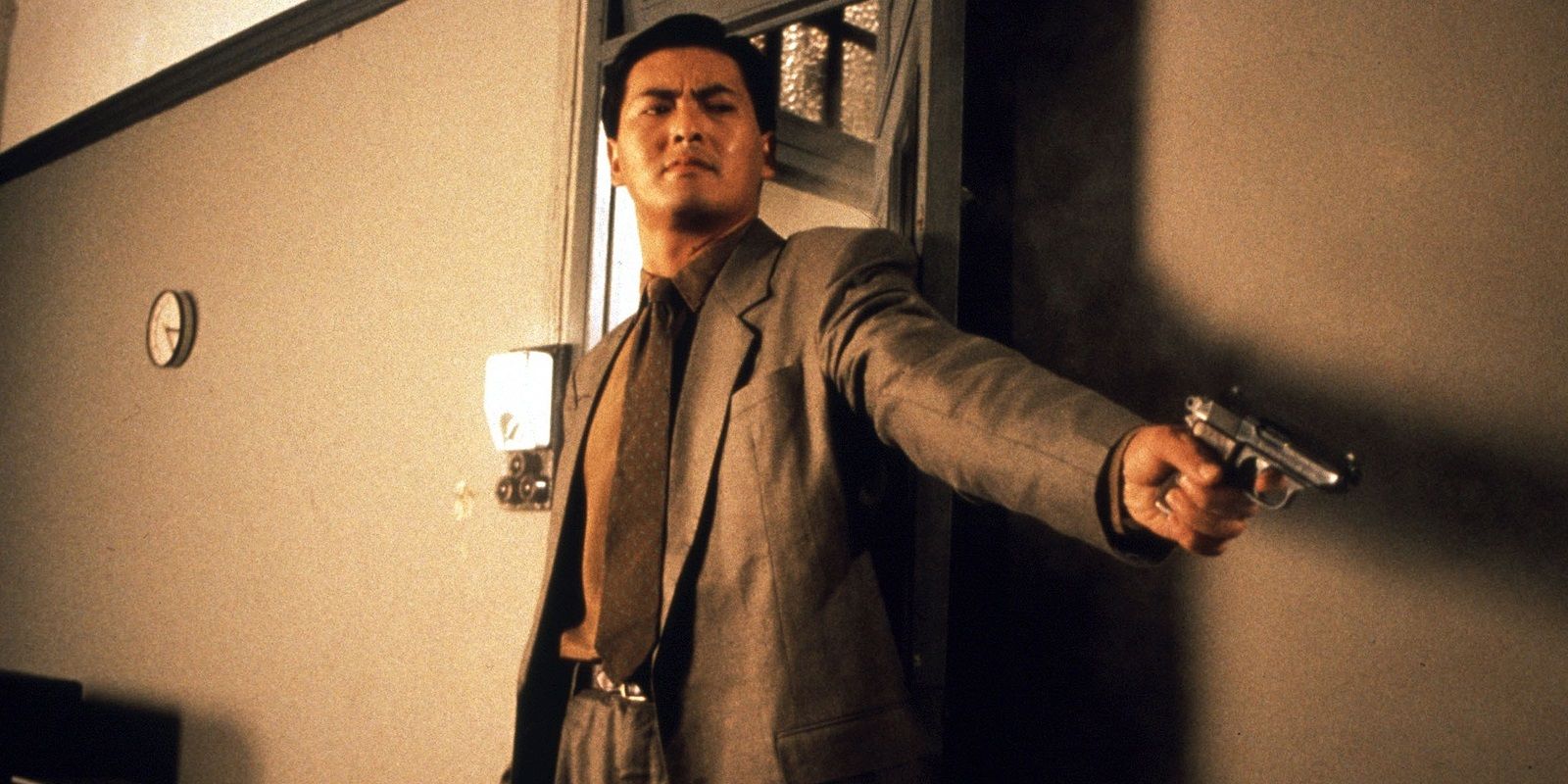 Chow Yun-fat aiming a pistol in The Killer