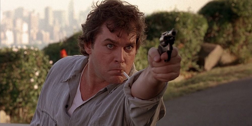 Ray Liotta points a gun off screen from Cop Land