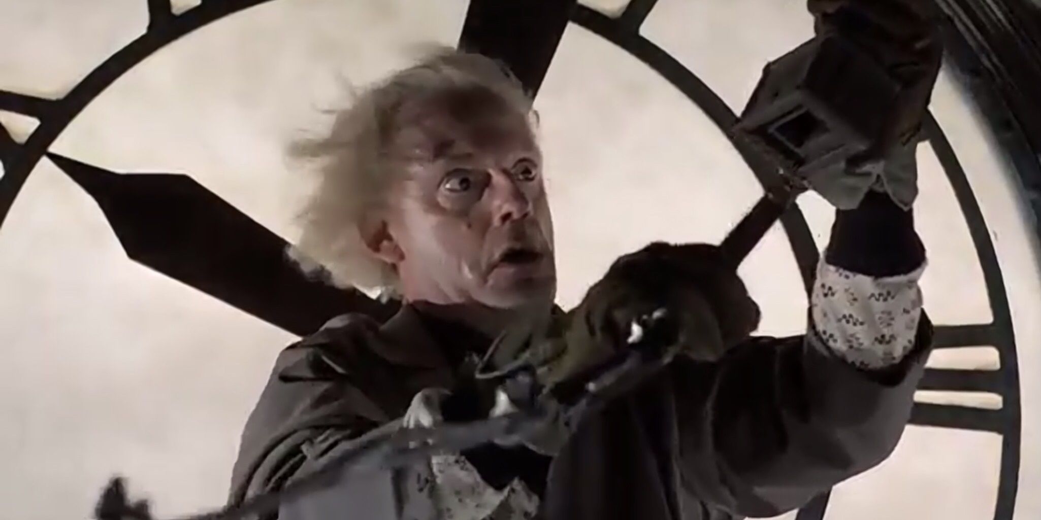 Doc hanging on to the hands of a clock on the clock tower in Back To The Future 