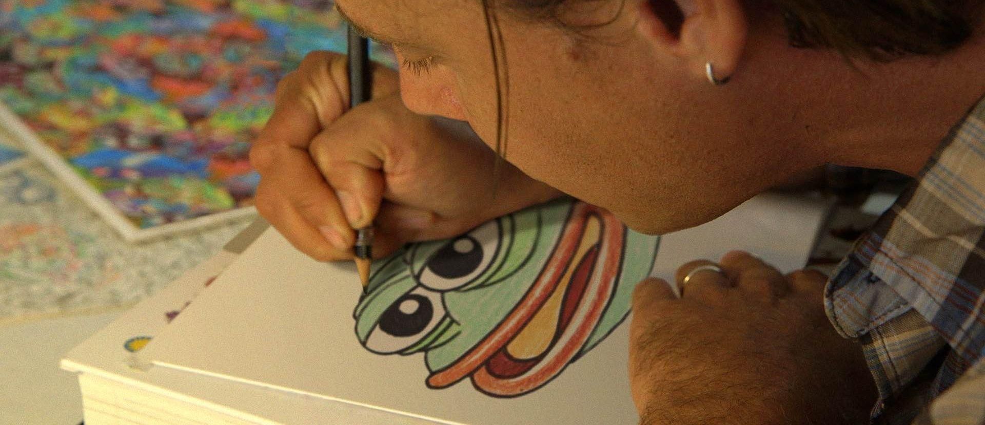 An artist drawing Pepe the Frog