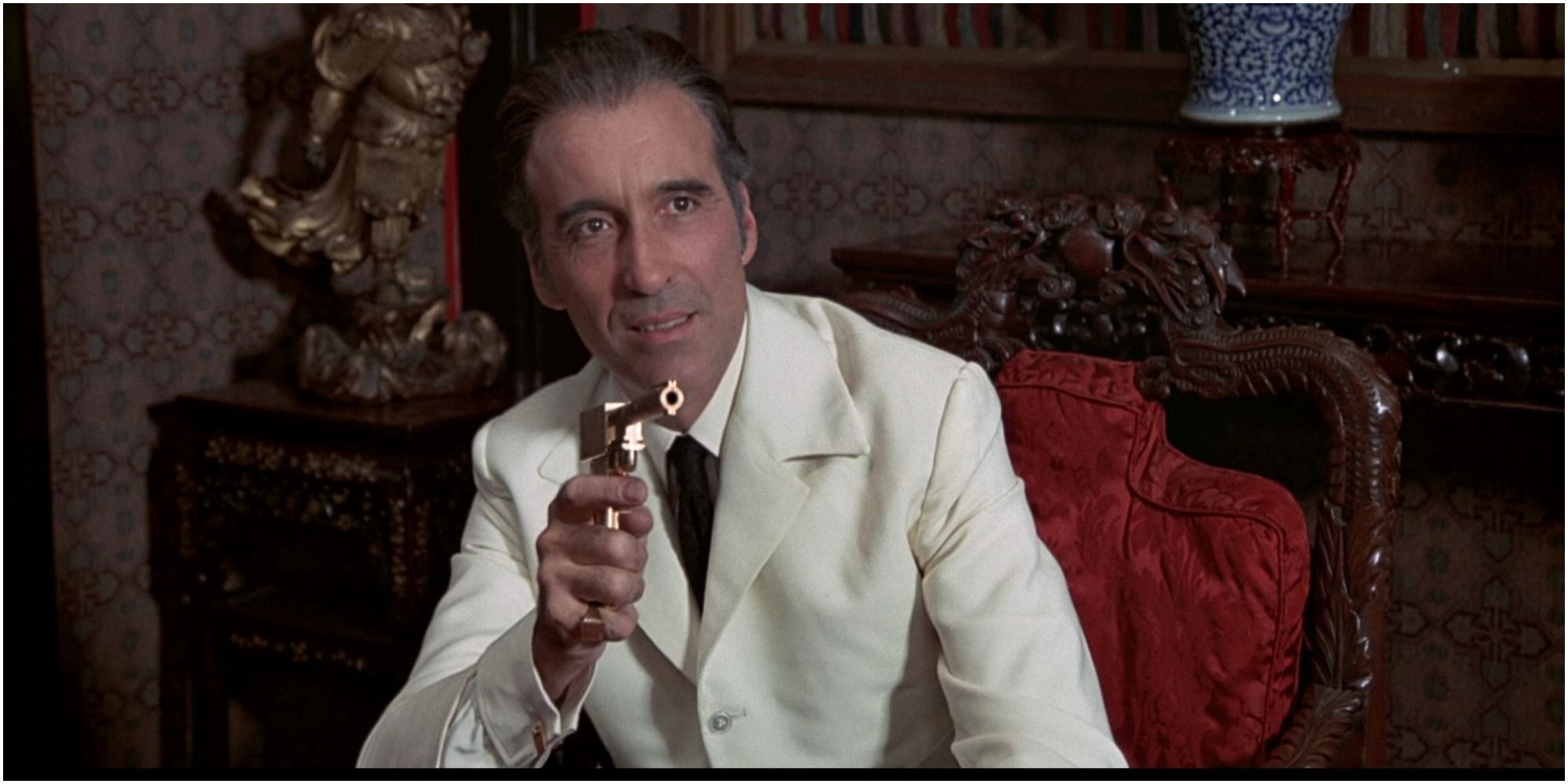 Scaramange points his gun at his mistress in The Man With The Golden Gun