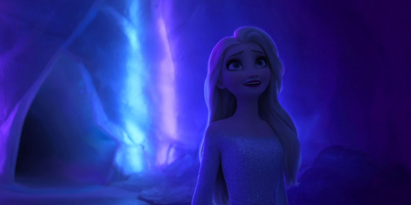 Elsa stands in a cave, looking up in wonder, in Frozen 2