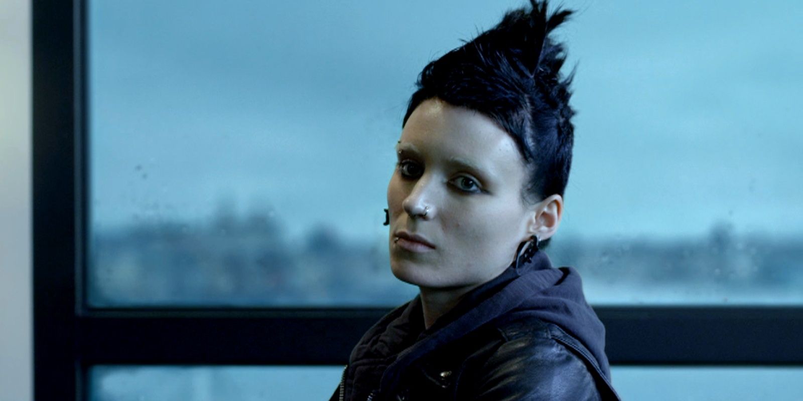 Lisbeth stands by a window in The Girl With The Dragon Tattoo
