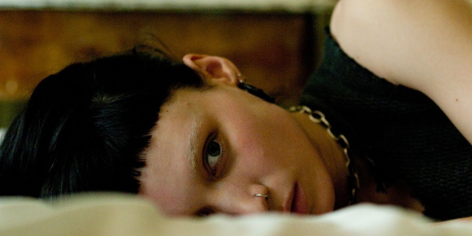 Lisbeth Salander sideways resting her head on a bed
