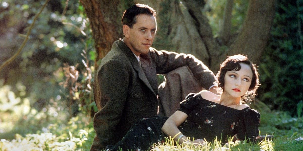 Richard E. Grant e Maria de Medeiros sentados na grama em Henry & June