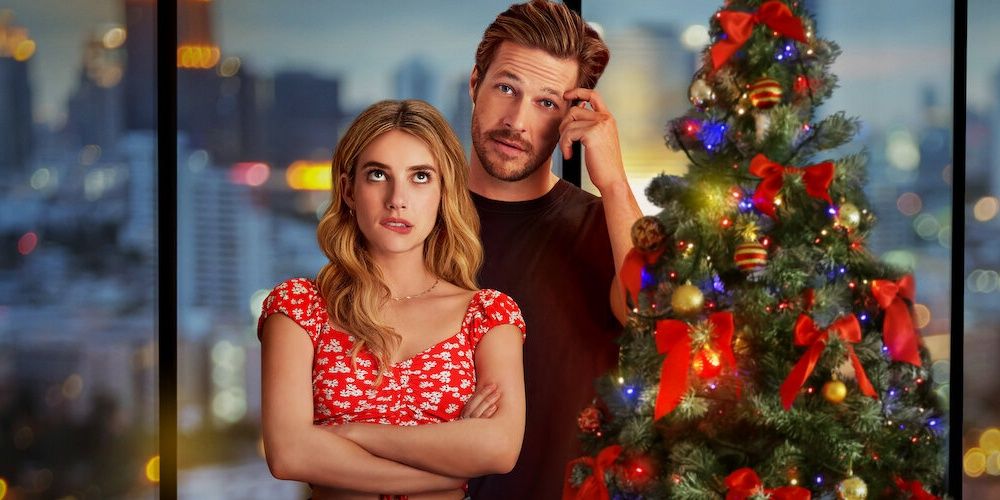 Two stars of Netflix's Holidate in a promo photo in front of a Christmas tree