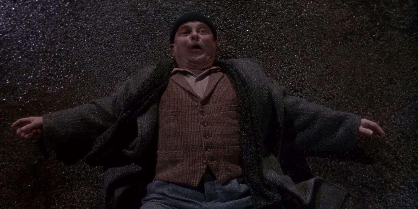 Harry wheezing on the concrete sidewalk in Home Alone (1990)