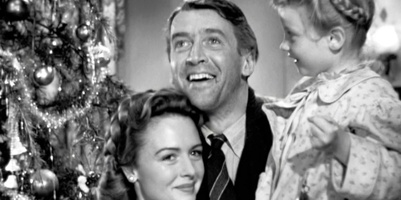 James Stewart as George Bailey with his family in It's a Wonderful Life during Christmas with a Christmas tree