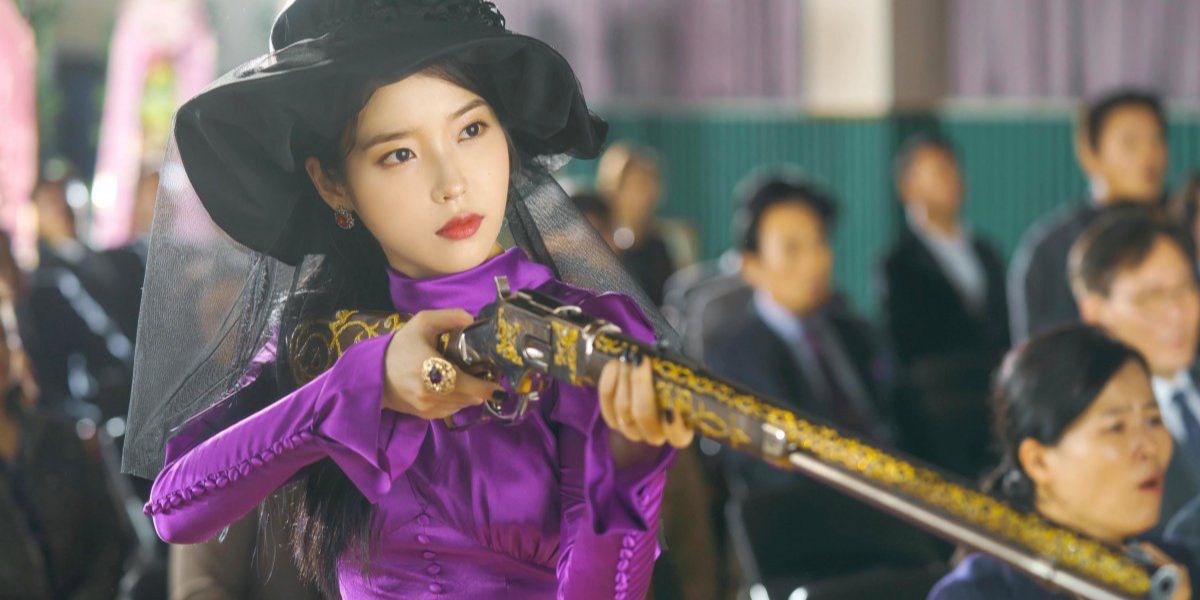 Jang Man‑Wol holding long shotgun in Hotel Del Luna