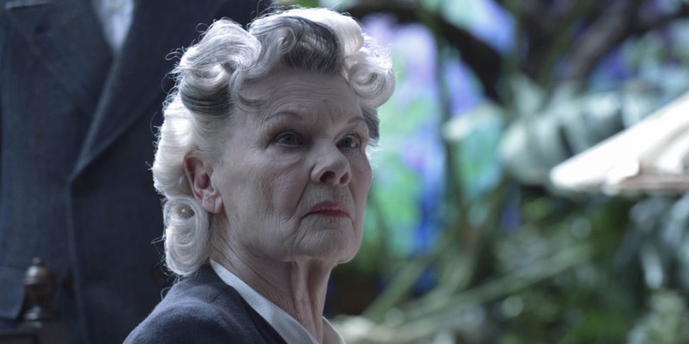 Judy Dench with her hair curled, looking stern