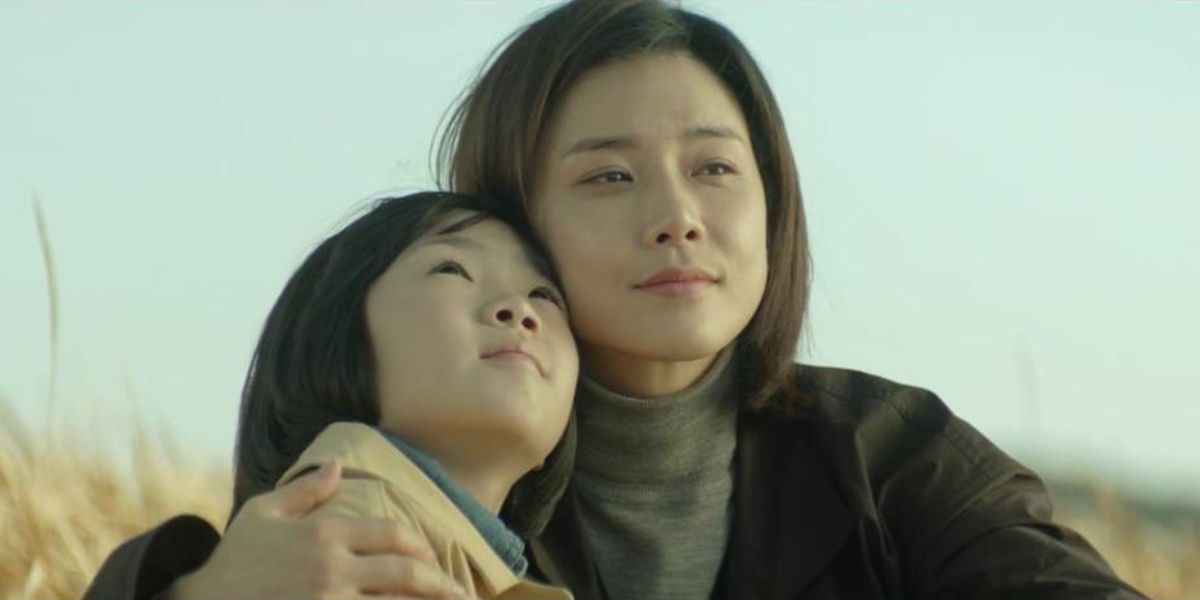 Soo-Jin and Hye-Na sitting in a field in Mother