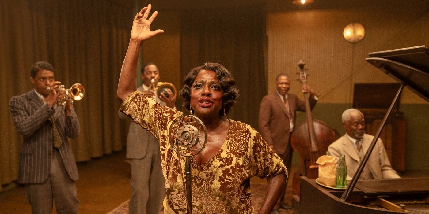 Viola Davis levantando a mão na frente do microfone enquanto a banda toca no Black Bottom de Ma Rainey Netflix