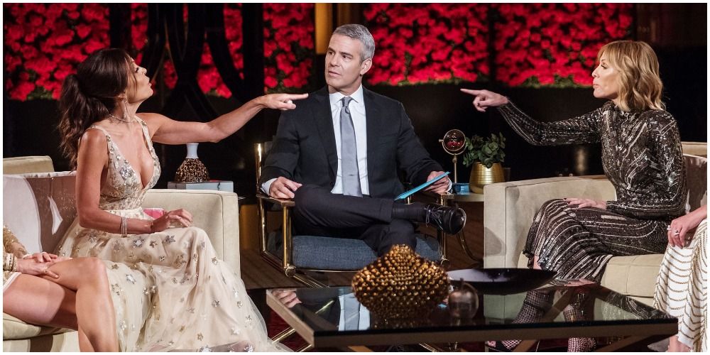 Bethenny and Carole arguing and pointing at each other sitting with Andy Cohen at a reunion of RHONY