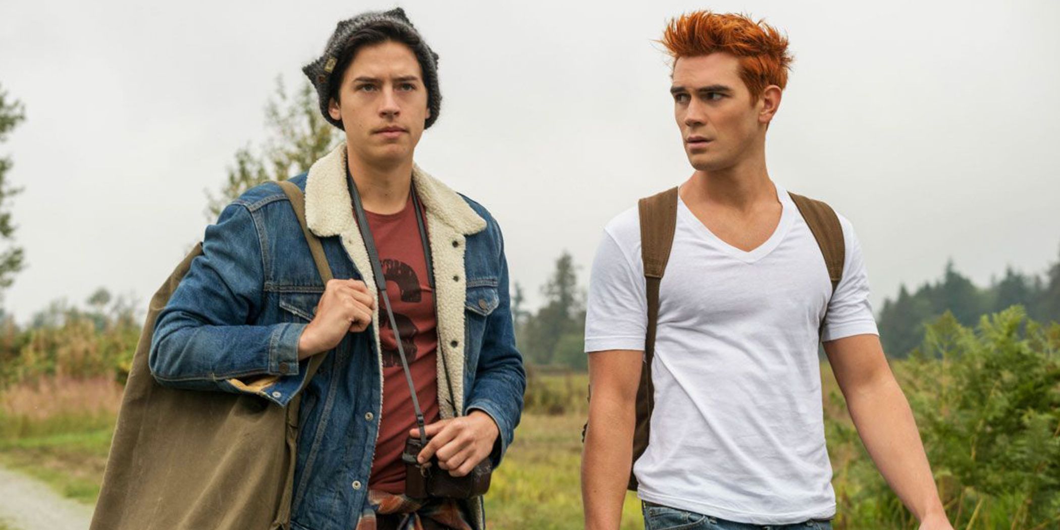 Archie and Jughead walk along a road side by side on Riverdale