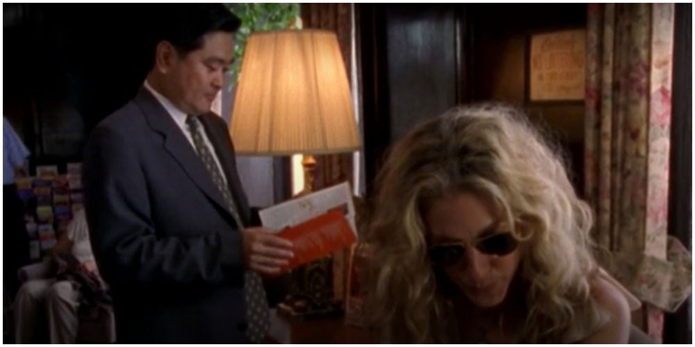 Businessman Looking At Brochure Behind Carrie