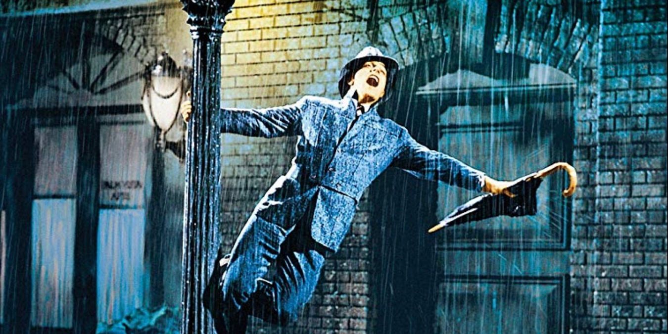 Don Lockwood swinging on a lightpost under the rain in Singin' In The Rain 1952