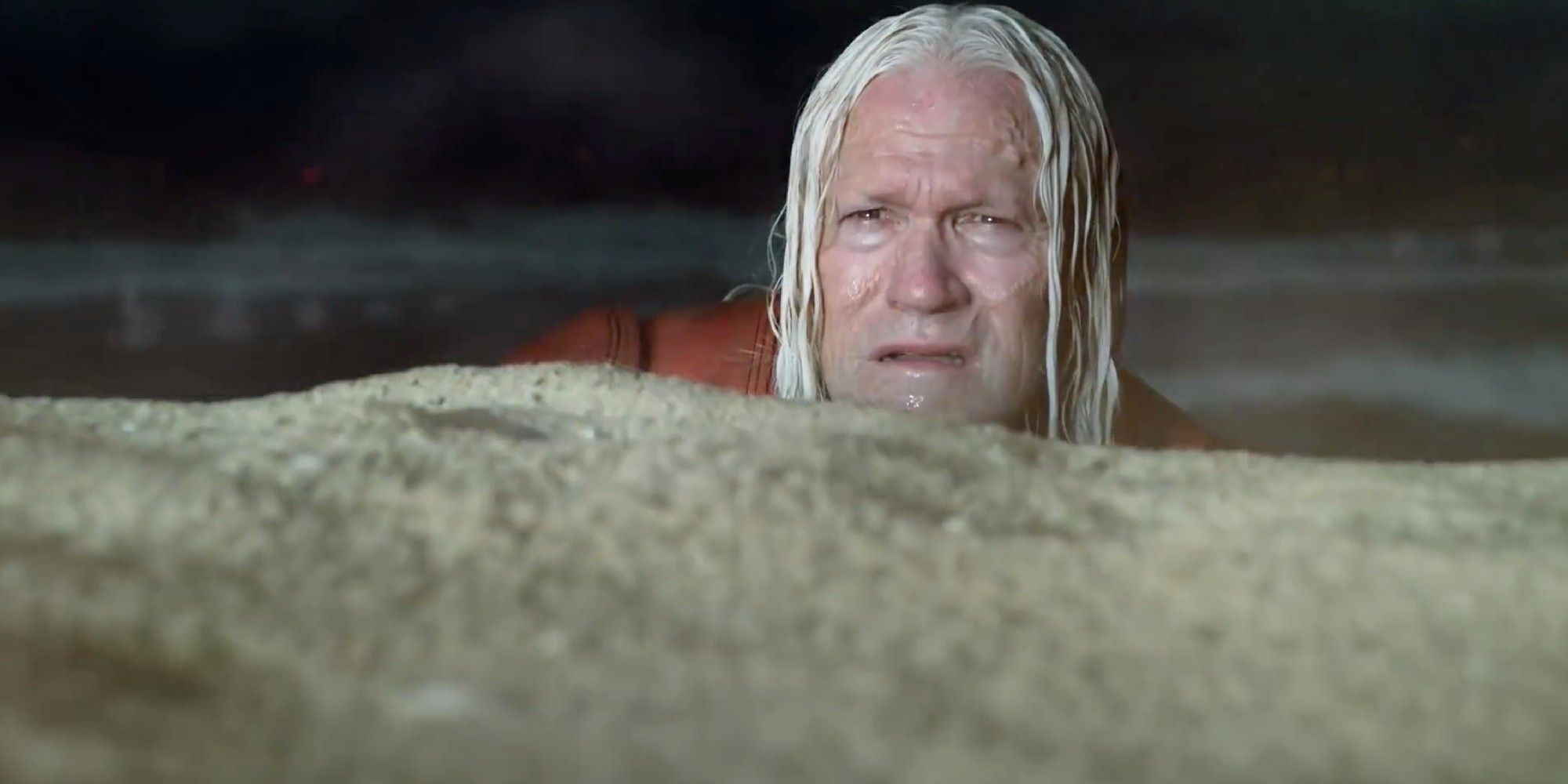 Michael Rooker as Savant peeking over a rock with confusion