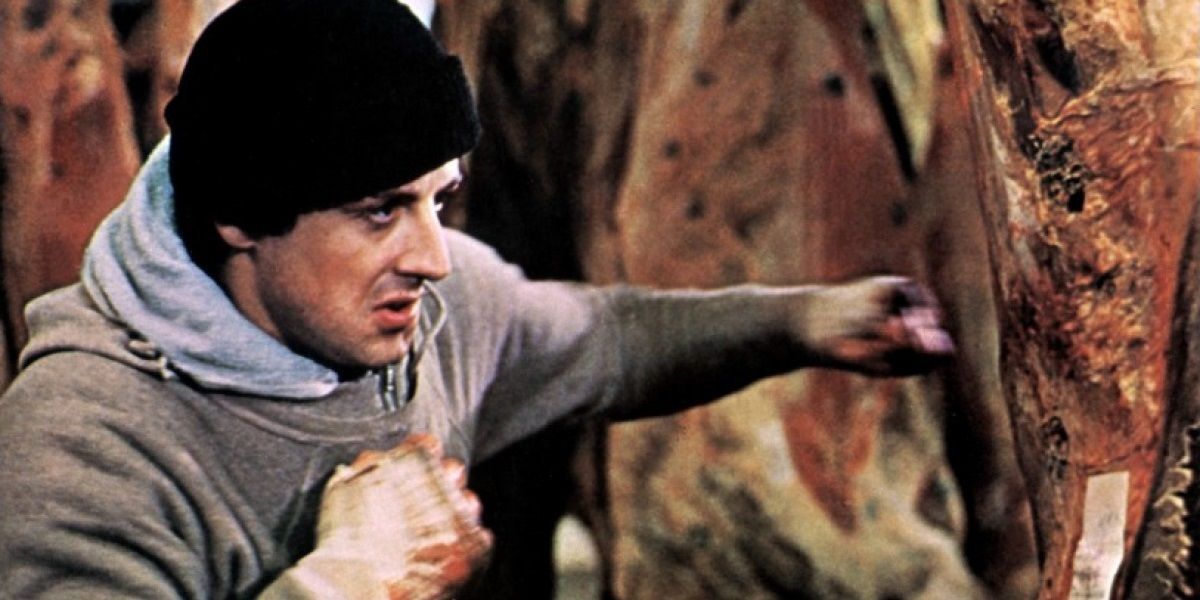 Sylvester Stallone as Rocky Balboa punching frozen meat